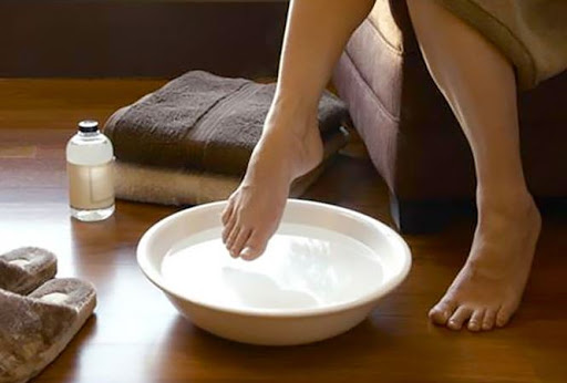 Ngâm chân với nước ấm và muối giúp giảm đau cho người bệnh gút