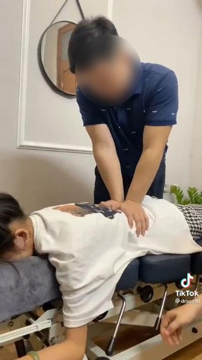 Một “thầy thuốc online” nhấn mạnh tay lên lưng tạo ra tiếng kêu của khớp xương được cho là để chữa gù lưng